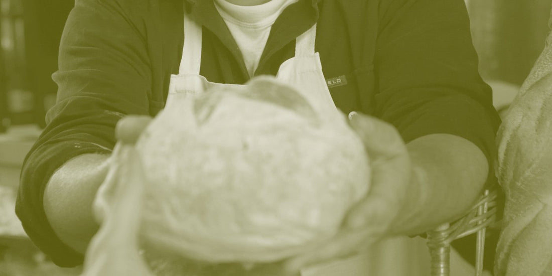 baker shows fresh sourdough loaf at Sunday market in Melbourne
